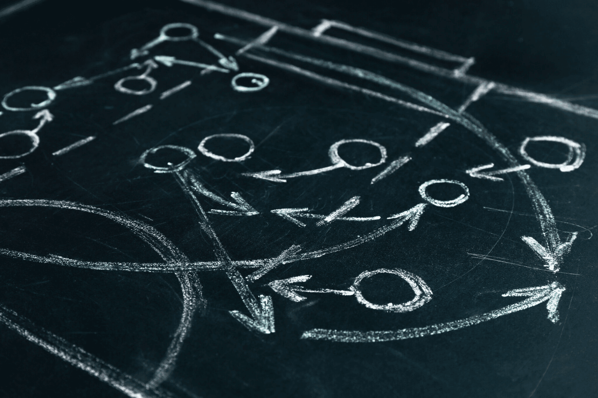 Chalkboard diagram with arrows and circles illustrating a strategic game plan.